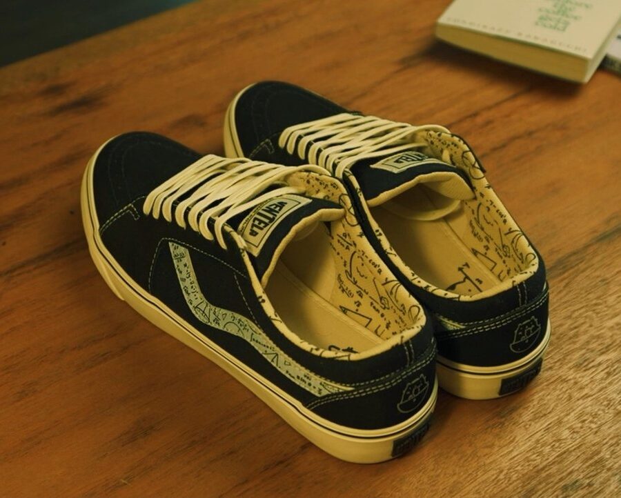 Sepasang sepatu Ventela x Jerome Polin navy dengan insole bergambar di atas meja kayu